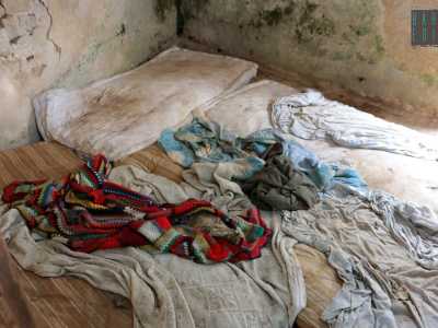 ...e di due materassi ricoperti da cuscini, coperte e maglioni, ci fanno capire come qui qualcuno ci abiti